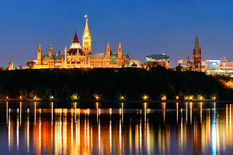 Ottawa at night over river with historical architecture