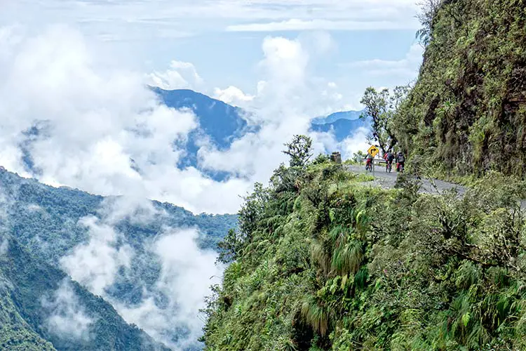 Mountain bikers riding the famous downhill trail "Road of death" in Bolivia