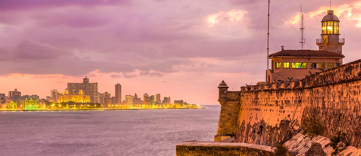 Beautiful sunset in Havana with El Morro lighthouse illuminated Featured Image