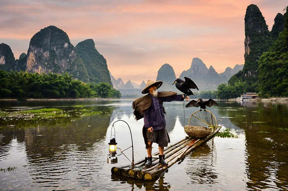 Cormorant fisherman with the Karst mountains of Guilin